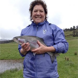 guest holding trout she has caught on her luxury hotel fly fishing experience